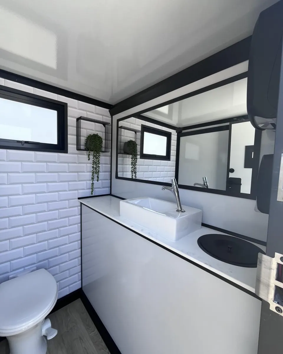 Restroom trailer sink beneath windows